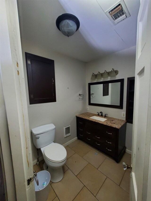 bathroom featuring tile patterned flooring, vanity, and toilet