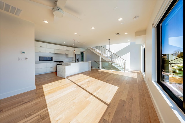 4575 Virginia Ave, Dallas, TX 75204 - unfurnished living room with a ceiling fan, light wood finished floors, recessed lighting, and stairway