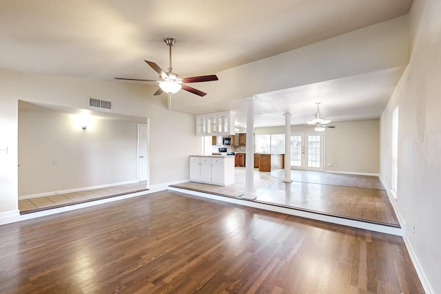 unfurnished living room with french doors, vaulted ceiling, ceiling fan, ornate columns, and wood-type flooring