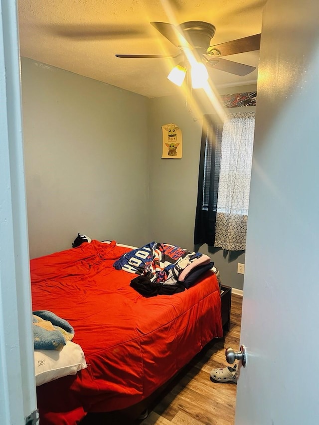 bedroom with ceiling fan and wood-type flooring