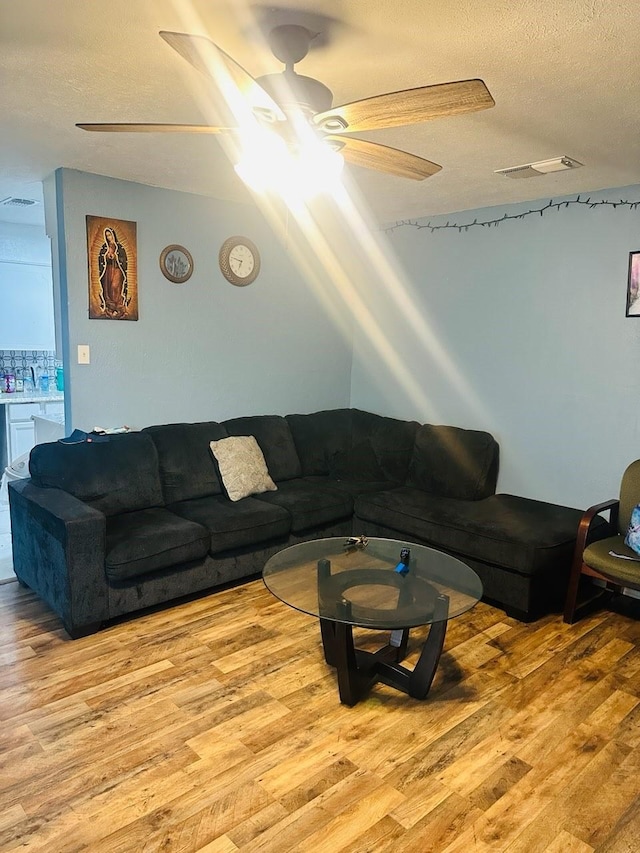 living room featuring light wood-type flooring and a textured ceiling