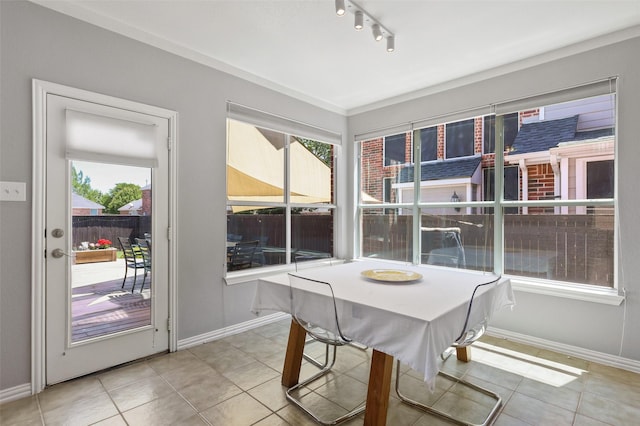 sunroom / solarium featuring track lighting and plenty of natural light