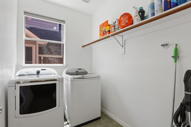 laundry room featuring washing machine and clothes dryer and dark tile patterned floors