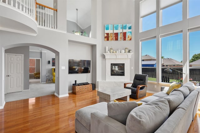 living room with hardwood / wood-style flooring, high vaulted ceiling, and a chandelier