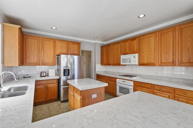 kitchen featuring white appliances, sink, light stone countertops, light tile patterned floors, and a kitchen island