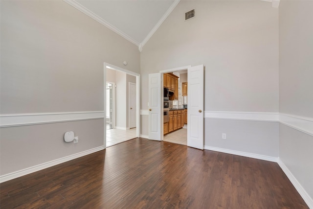 spare room with light wood-type flooring, high vaulted ceiling, and crown molding