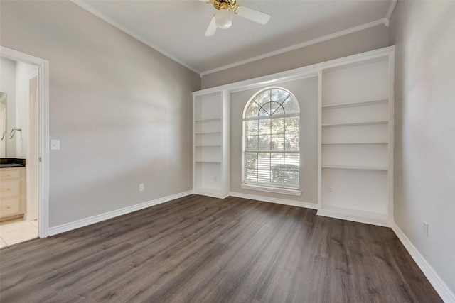 empty room featuring dark hardwood / wood-style flooring, ceiling fan, and crown molding