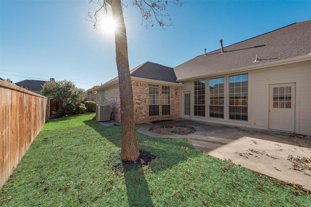 rear view of house with a lawn, central air condition unit, and a patio