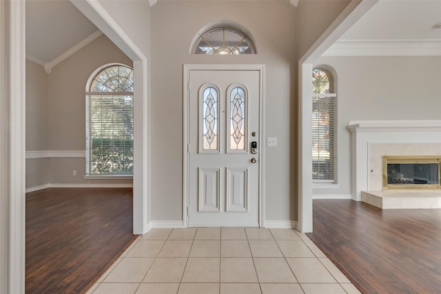 entryway with light hardwood / wood-style flooring, a wealth of natural light, and crown molding