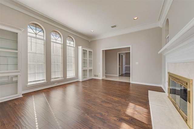 unfurnished living room featuring hardwood / wood-style floors, a tile fireplace, and a wealth of natural light