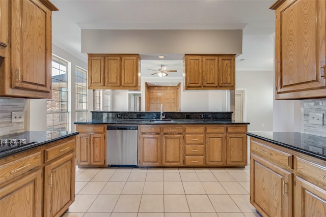 kitchen featuring dishwasher, dark stone countertops, sink, and tasteful backsplash