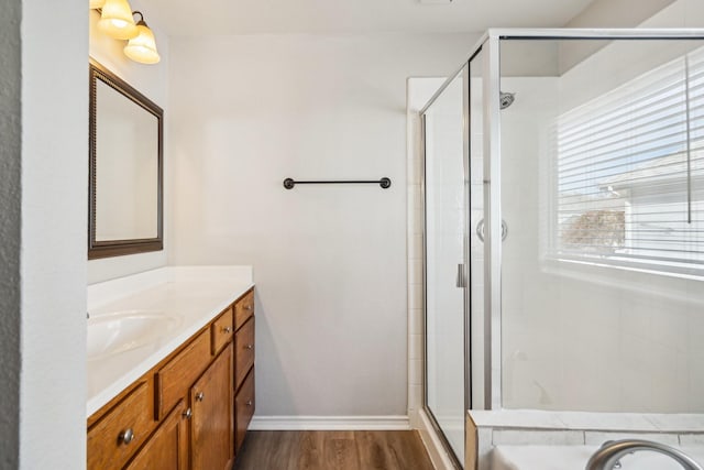 bathroom featuring plus walk in shower, hardwood / wood-style floors, and vanity