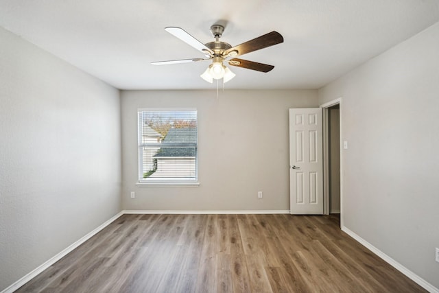 empty room featuring dark hardwood / wood-style flooring and ceiling fan