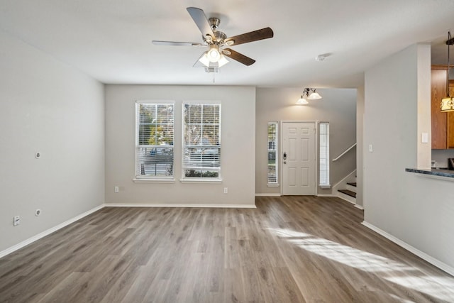 unfurnished living room featuring ceiling fan and wood-type flooring