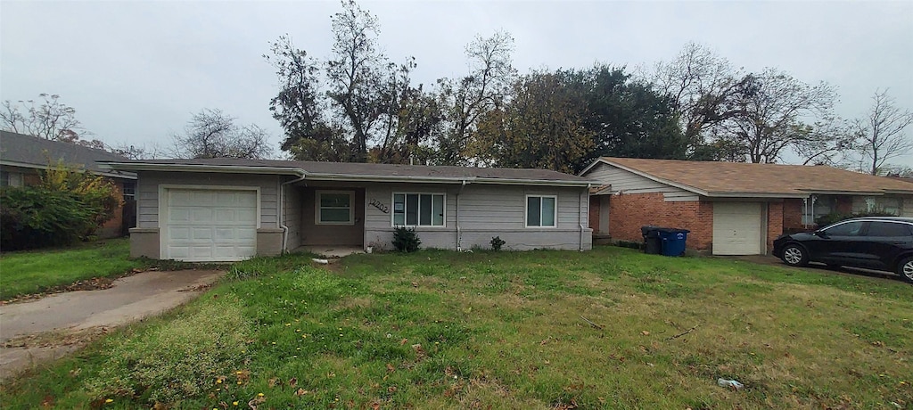 ranch-style house featuring a front lawn and a garage