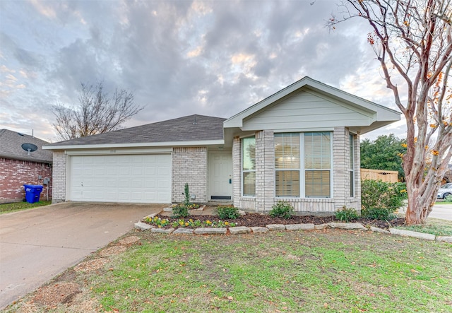 single story home with concrete driveway, an attached garage, brick siding, and a front yard