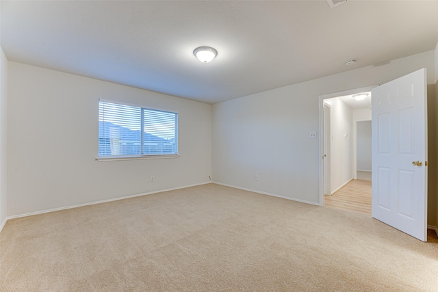 spare room featuring light carpet