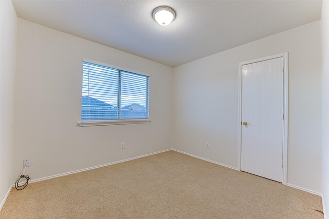 unfurnished room with light carpet