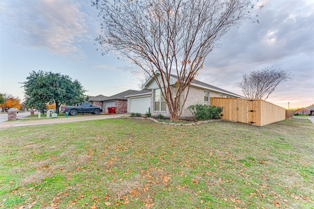 view of front facade featuring brick siding, a front yard, an attached garage, and driveway