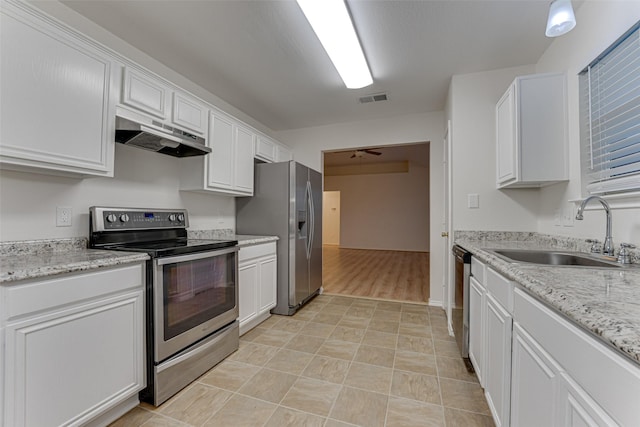 kitchen featuring white cabinets, sink, ceiling fan, light stone counters, and stainless steel appliances