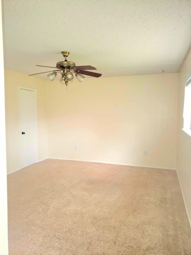 unfurnished room featuring ceiling fan, carpet floors, and a textured ceiling