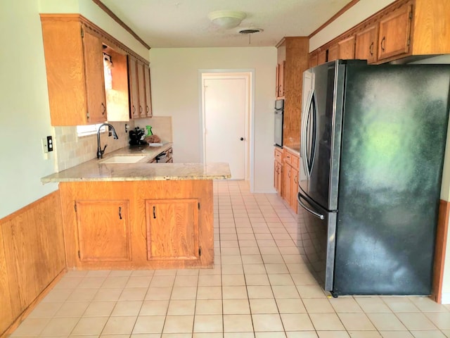 kitchen featuring sink, stainless steel appliances, backsplash, kitchen peninsula, and light tile patterned floors