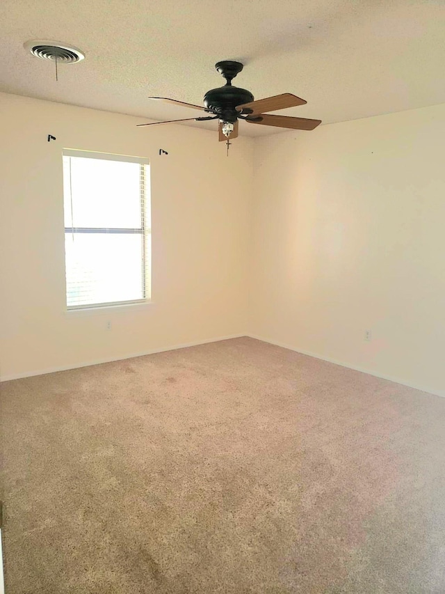 carpeted empty room featuring a textured ceiling and ceiling fan