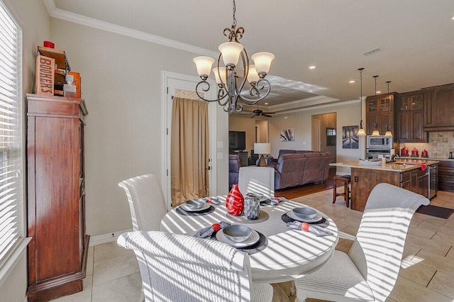 tiled dining room with ornamental molding, ceiling fan with notable chandelier, and sink