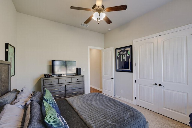 bedroom with light carpet, ceiling fan, and a closet