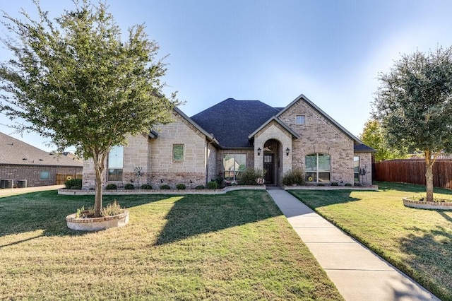 french provincial home with a front yard