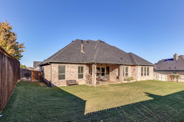 rear view of property featuring a lawn and a patio