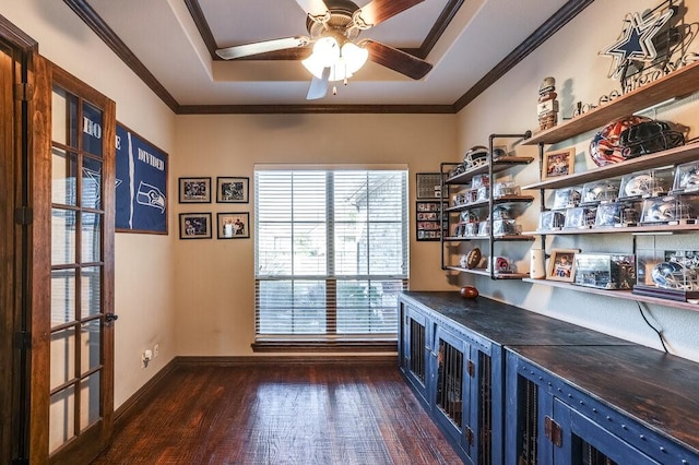 unfurnished office with ceiling fan, crown molding, a raised ceiling, and dark hardwood / wood-style floors