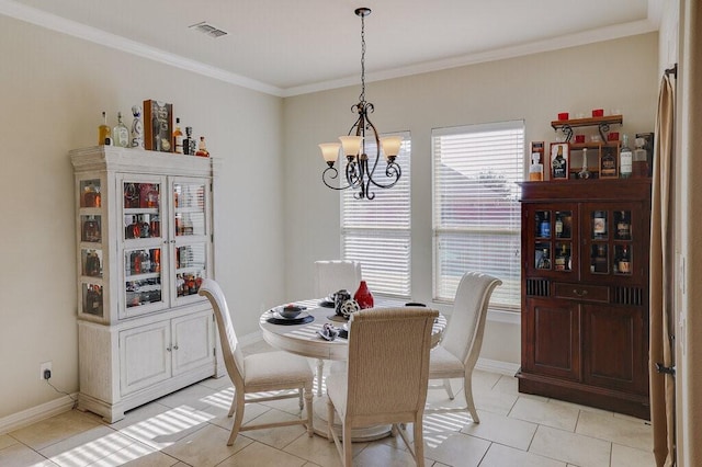 tiled dining room featuring ornamental molding and a chandelier