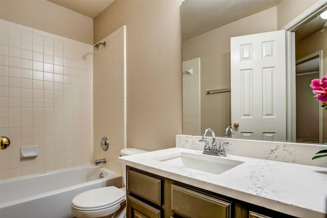 full bathroom featuring vanity, tiled shower / bath combo, and toilet