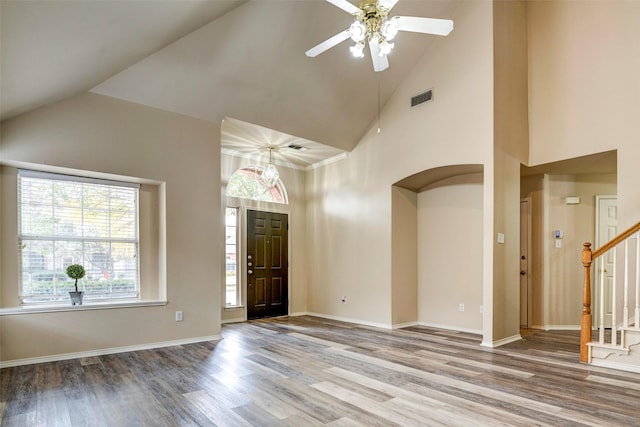 empty room with wood-type flooring, ceiling fan, and high vaulted ceiling