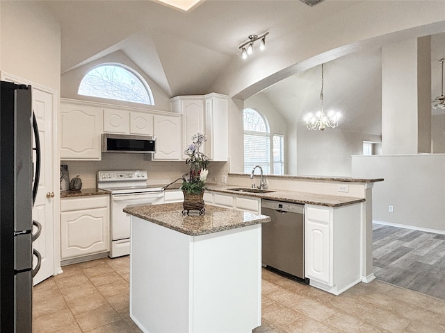 kitchen featuring appliances with stainless steel finishes, sink, white cabinets, hanging light fixtures, and a center island