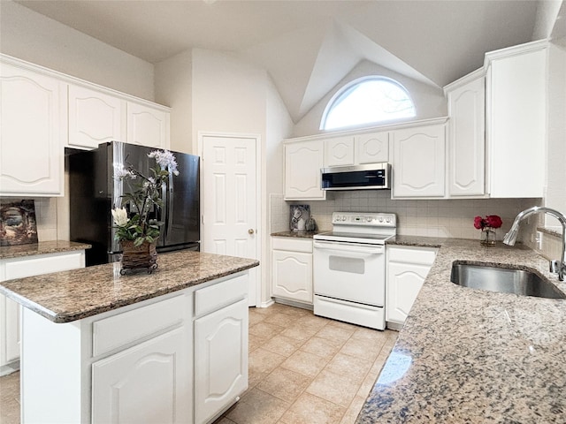 kitchen featuring electric stove, sink, white cabinetry, a kitchen island, and black fridge