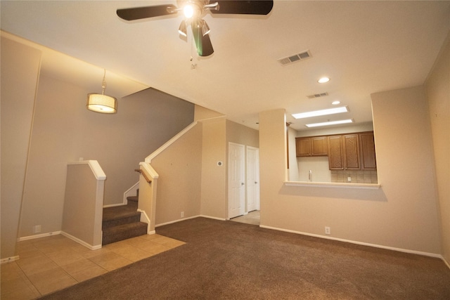 unfurnished living room with visible vents, baseboards, ceiling fan, stairway, and carpet floors