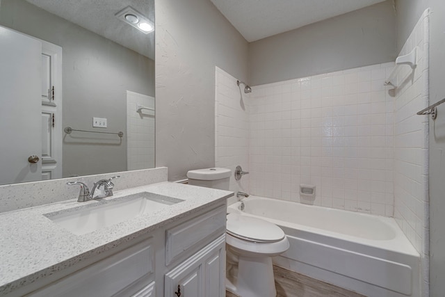 full bathroom featuring tiled shower / bath combo, a textured ceiling, toilet, vanity, and hardwood / wood-style flooring