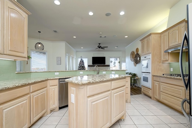 kitchen featuring tasteful backsplash, stainless steel appliances, and light brown cabinetry