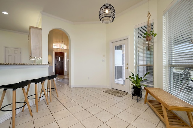 interior space with light tile patterned floors and crown molding