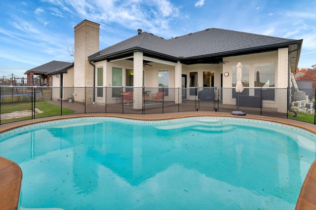 view of swimming pool featuring ceiling fan and a patio area