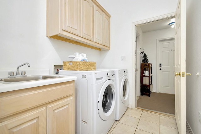 laundry area featuring light tile patterned flooring, cabinets, separate washer and dryer, and sink