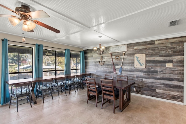 dining space with tile patterned floors, wooden walls, and ceiling fan with notable chandelier