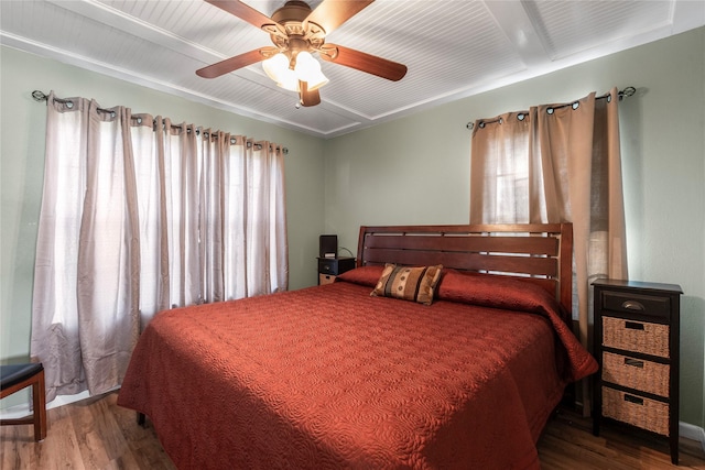 bedroom featuring beam ceiling, multiple windows, ceiling fan, and wood-type flooring