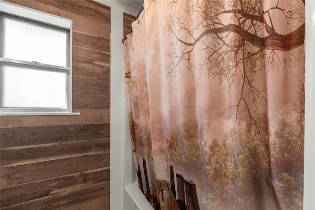 bathroom with wood walls and shower / bath combination with curtain