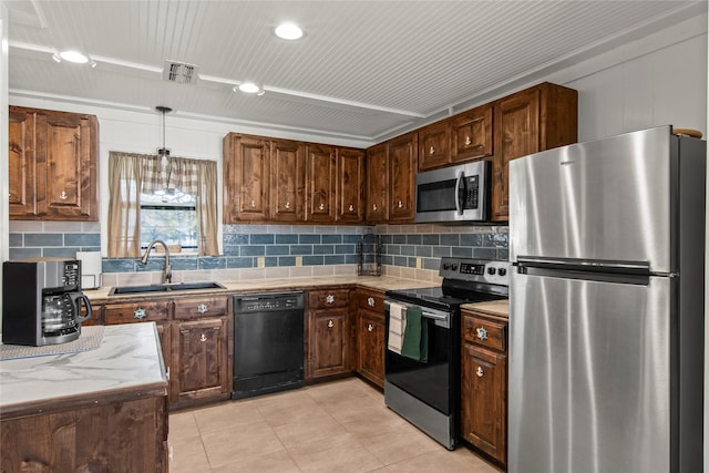 kitchen featuring decorative backsplash, sink, hanging light fixtures, and appliances with stainless steel finishes