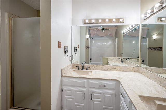 bathroom featuring vanity and a shower with door