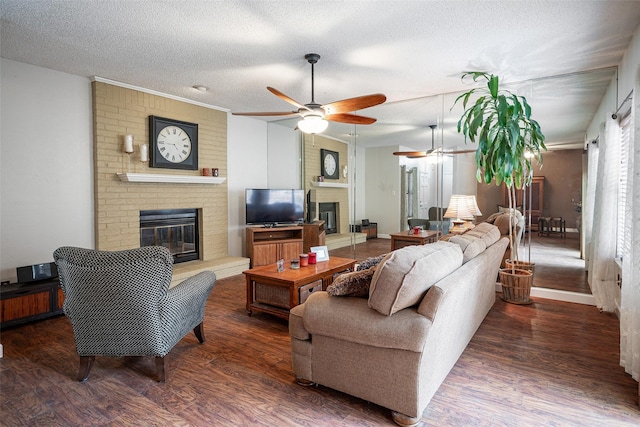 living room with a textured ceiling, ceiling fan, a fireplace, and dark hardwood / wood-style floors