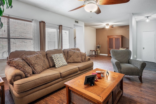 living room with a textured ceiling and dark wood-type flooring